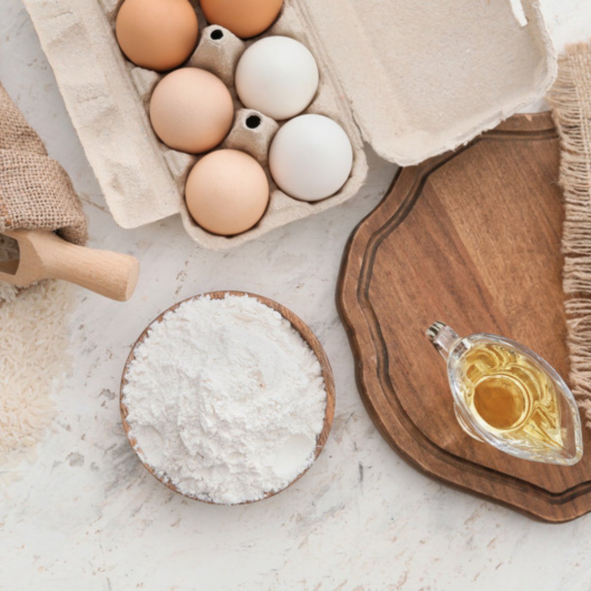 Organic flour, rice and oil cooking staples on a wooden board